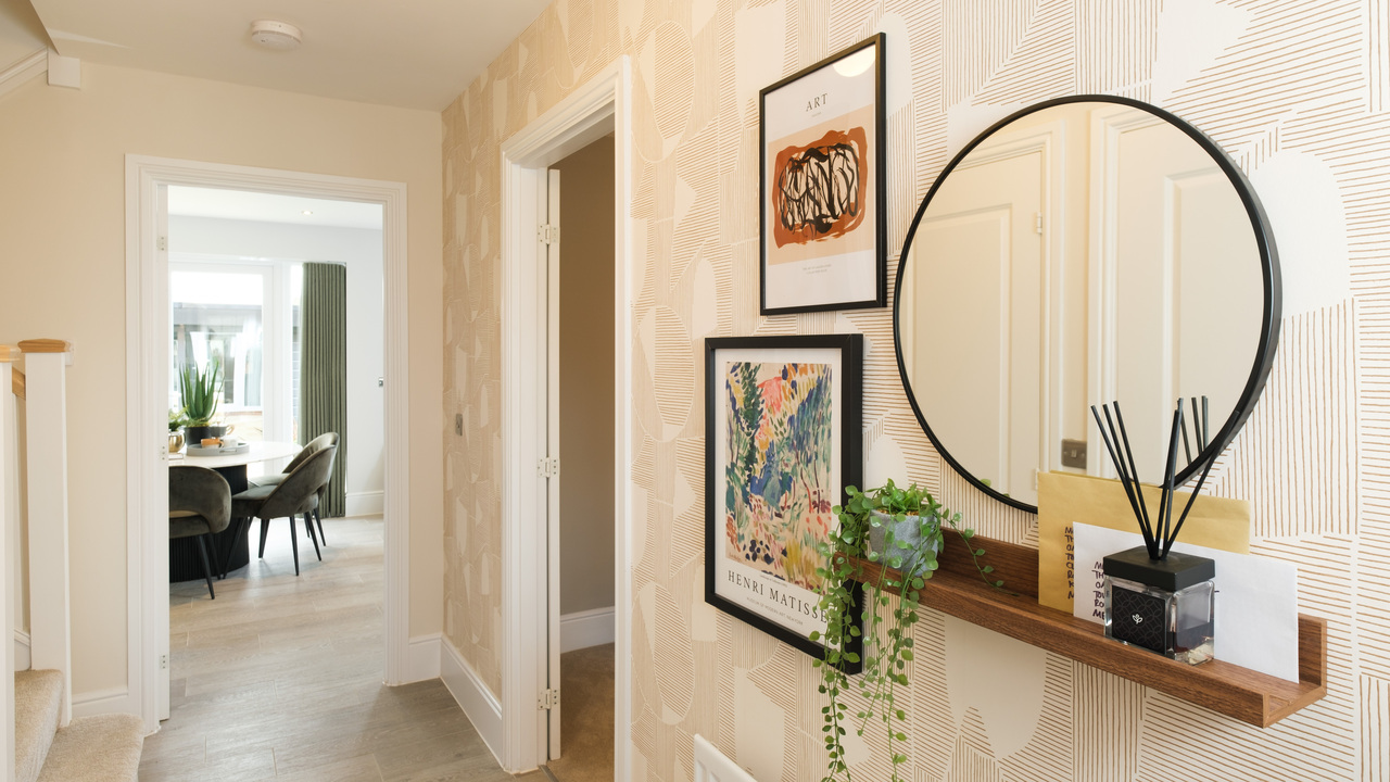 Redrow - Inspiration - Hallway with round mirror and pictures on the wall