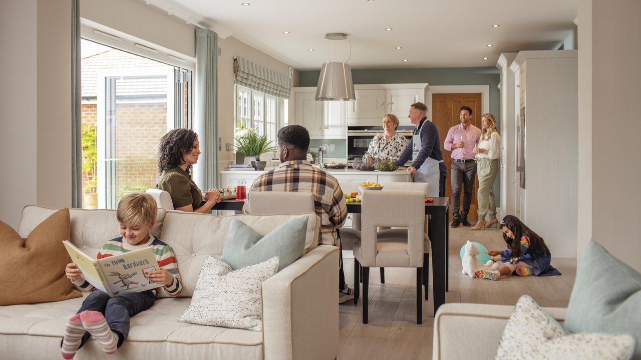 Redrow - Inspiration - Couples in kitchen talking with children reading book and playing with toys