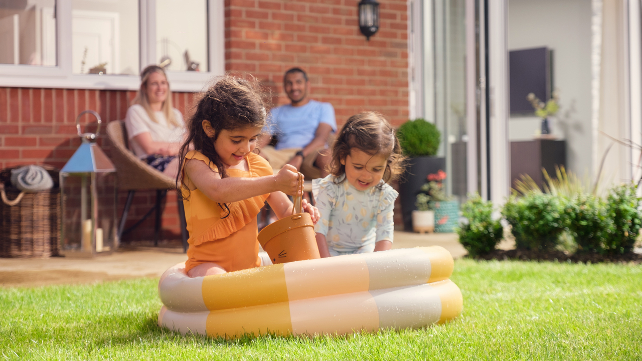 Redrow  Inspiration  Parents relaxing children playing in a Redrow home garden