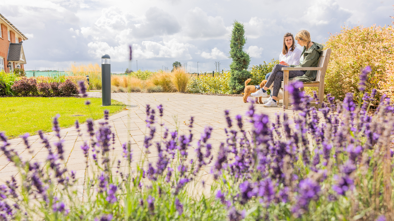 Redrow - Inspiration - 2 people sat on bench in a Redrow Development