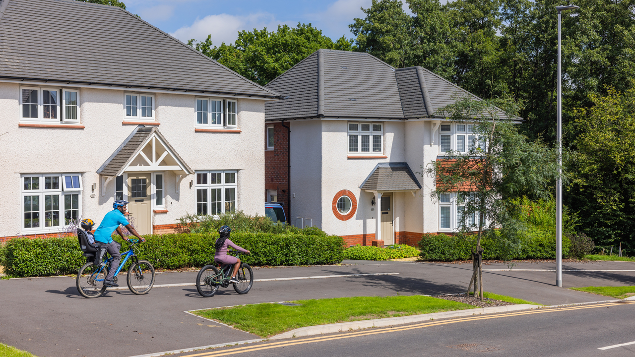 Redrow - Inspiration - Family riding bikes in Redrow Development